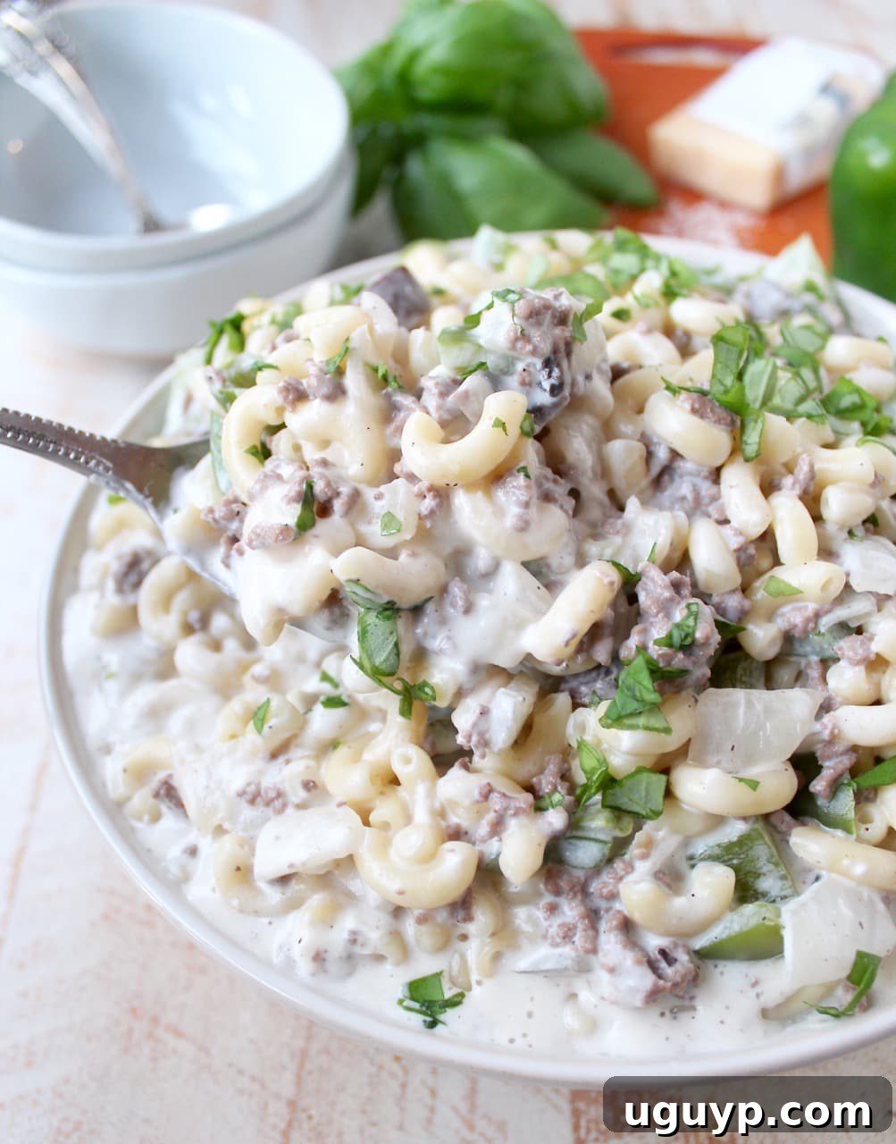 prepared cheesesteak mac and cheese in bowl with serving spoon