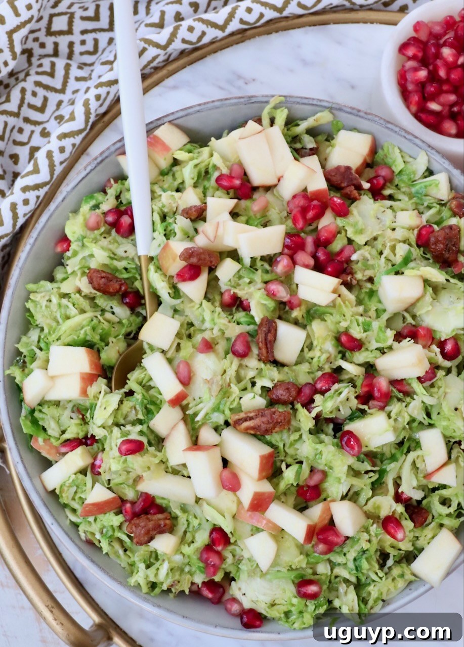 A large serving bowl filled with shaved Brussels Sprout Salad, showcasing the vibrant ingredients, with a serving spoon ready to dish out generous portions for a gathering.