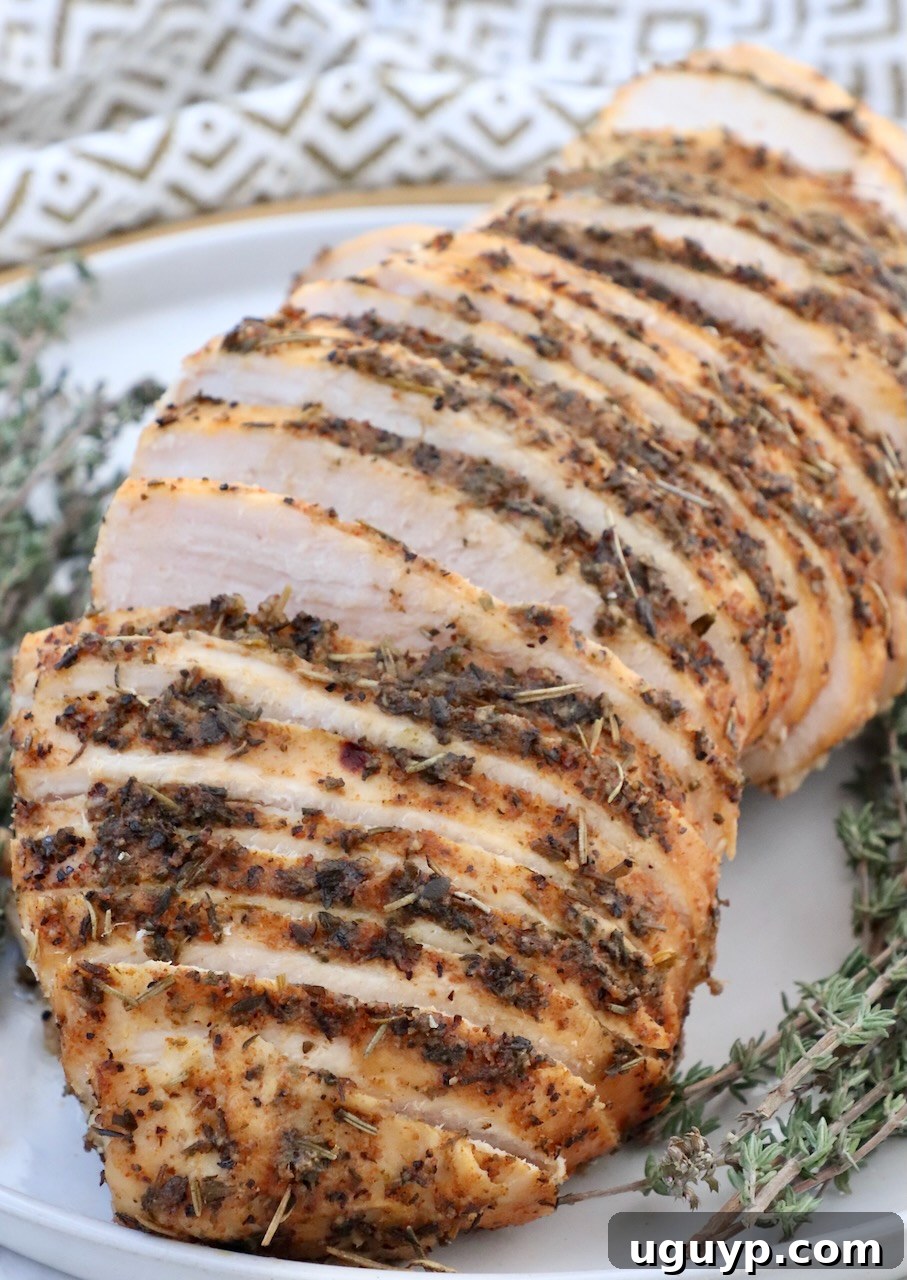 Sliced slow cooker turkey breast on a plate with fresh thyme garnish