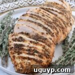 Sliced slow cooker turkey breast on a plate with fresh thyme garnish