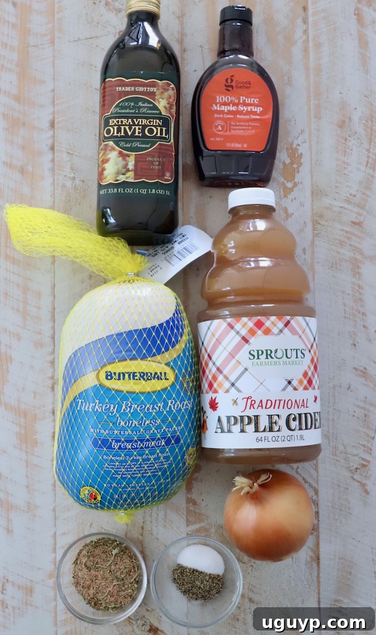 Ingredients for maple apple turkey breast arranged on a white wooden board