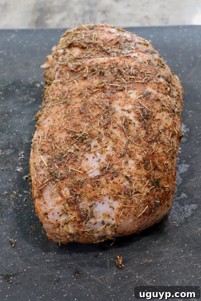 Seasoned turkey breast on a cutting board, ready for the slow cooker