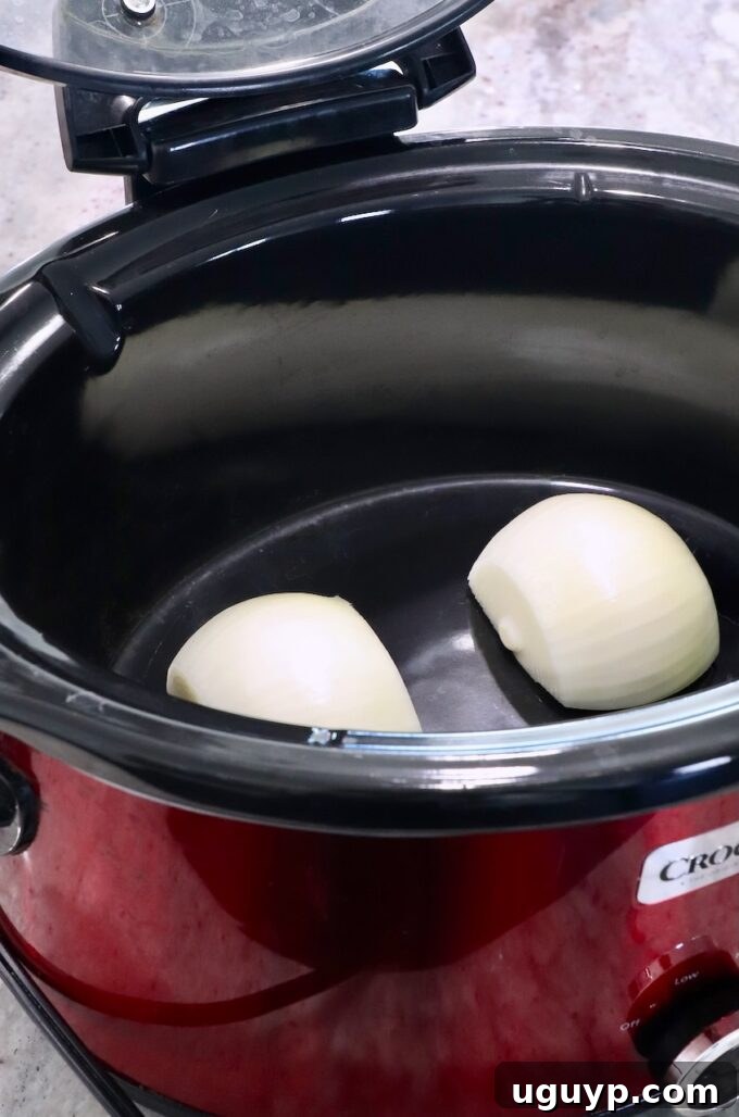 Onion cut in half placed in the bottom of a Crock Pot