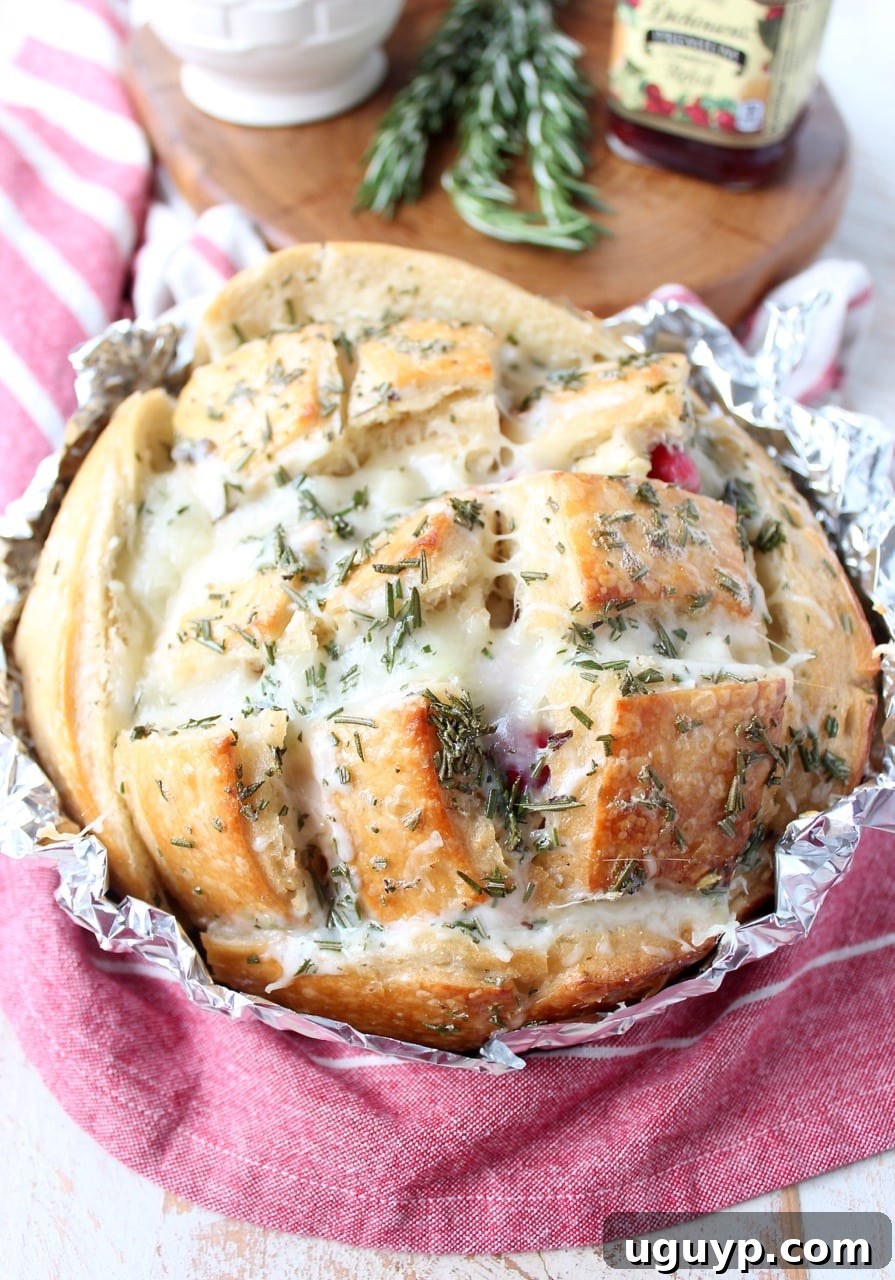 Delicious pull apart bread made with leftover Thanksgiving turkey and cranberry sauce, filled with melted mozzarella cheese and drizzled with fragrant rosemary butter, perfect for holiday gatherings or game day snacks.