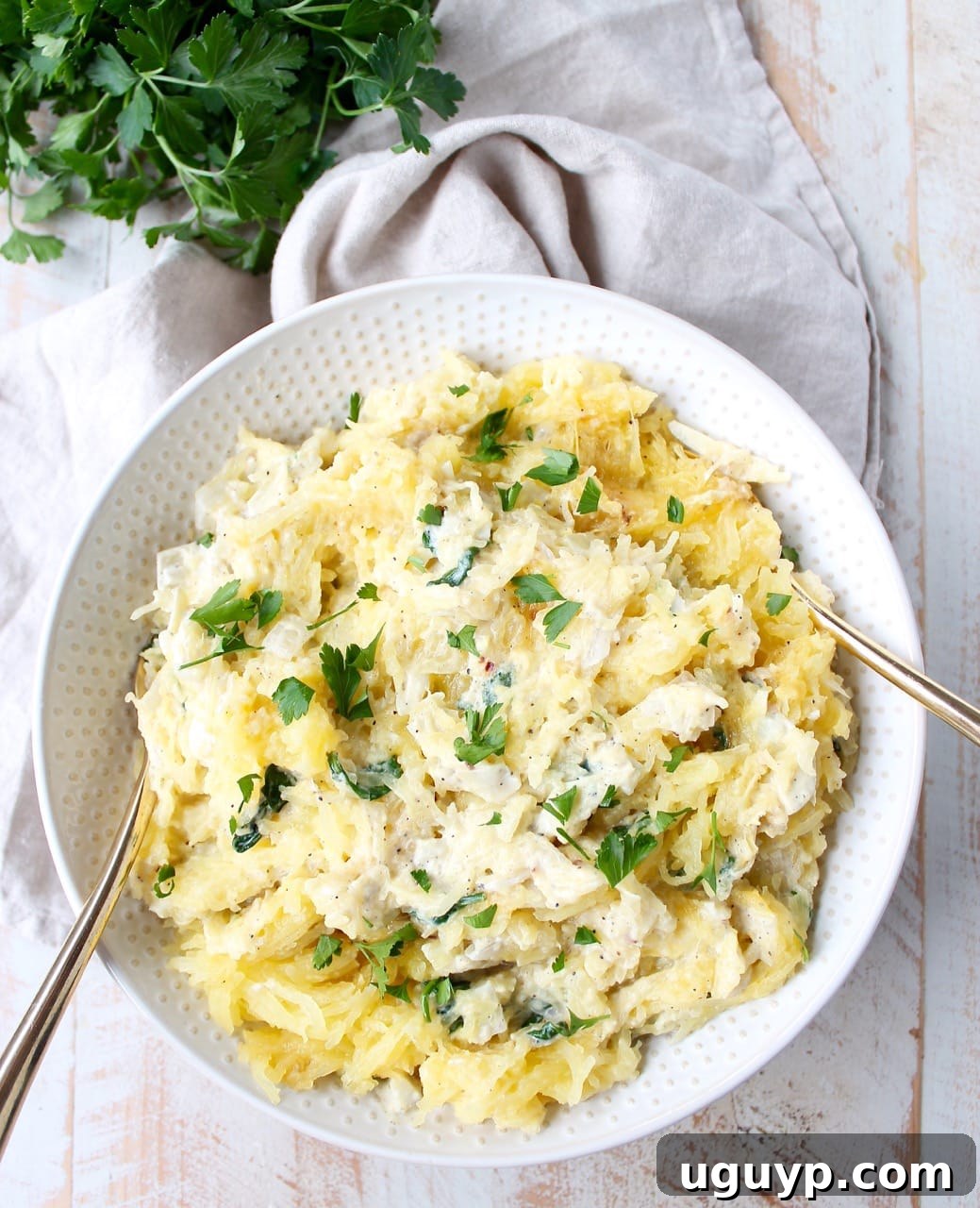 Baked spaghetti squash is tossed with a simple spinach artichoke sauce in this healthy, gluten free and vegetarian recipe, made in under an hour!