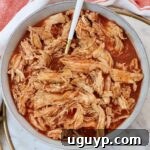 shredded chicken in buffalo sauce in a bowl with a fork