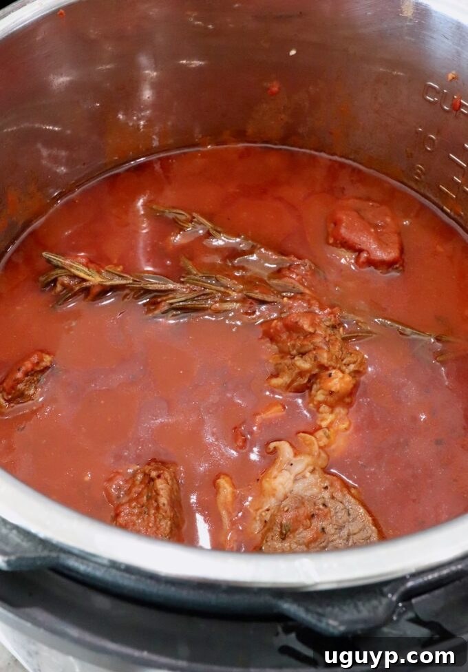 Cooked beef ragu sauce simmering in an Instant Pot after pressure cooking, rich in color and texture.