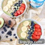 A beautifully presented vegan avocado smoothie bowl, garnished with a variety of fresh fruits and crunchy toppings, showcasing its inviting texture and vibrant green color.