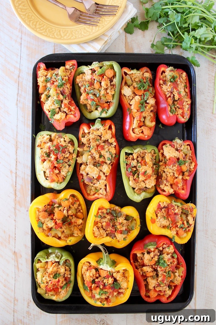 Vibrantly colored bell peppers stuffed with buffalo chicken mixture, beautifully arranged on a baking sheet, ready for serving.