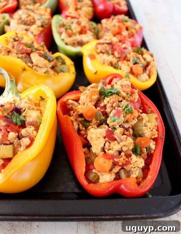 Close-up of a bell pepper half filled with a savory mixture of ground buffalo chicken, finely diced carrots, and other vegetables.