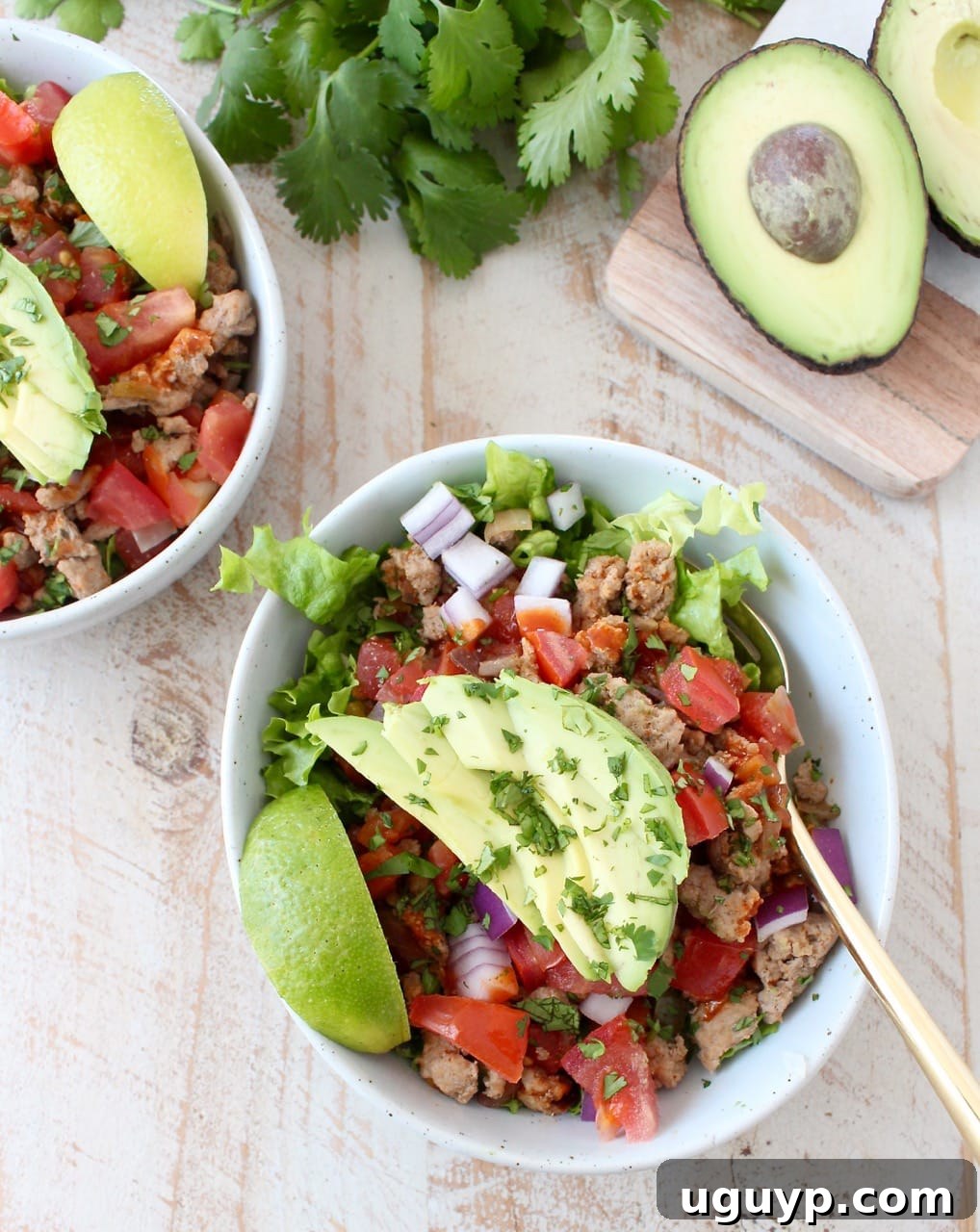 A pristine white bowl showcasing a delightful Turkey Taco Salad, with a vibrant base of fresh lettuce generously topped with seasoned ground turkey, colorful bell peppers, onions, and diced tomatoes, ready to be enjoyed.