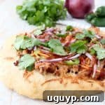 Delicious Banh Mi Pizza with sesame ginger ground pork, fresh carrots, jalapenos, cilantro, and Sriracha