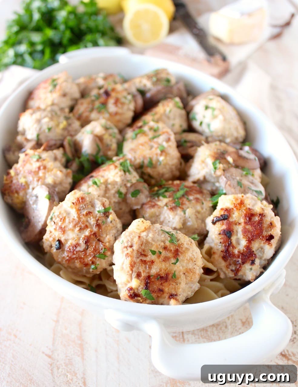 Cooked chicken and pork meatballs nestled in a creamy mushroom marsala sauce, ready to be served over noodles.