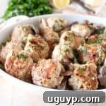 Cooked chicken and pork meatballs nestled in a creamy mushroom marsala sauce, ready to be served over noodles.