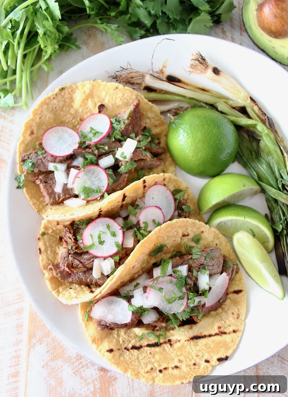 Authentic Carne Asada Tacos artfully arranged with thinly sliced radishes, a traditional topping that adds a peppery crunch.