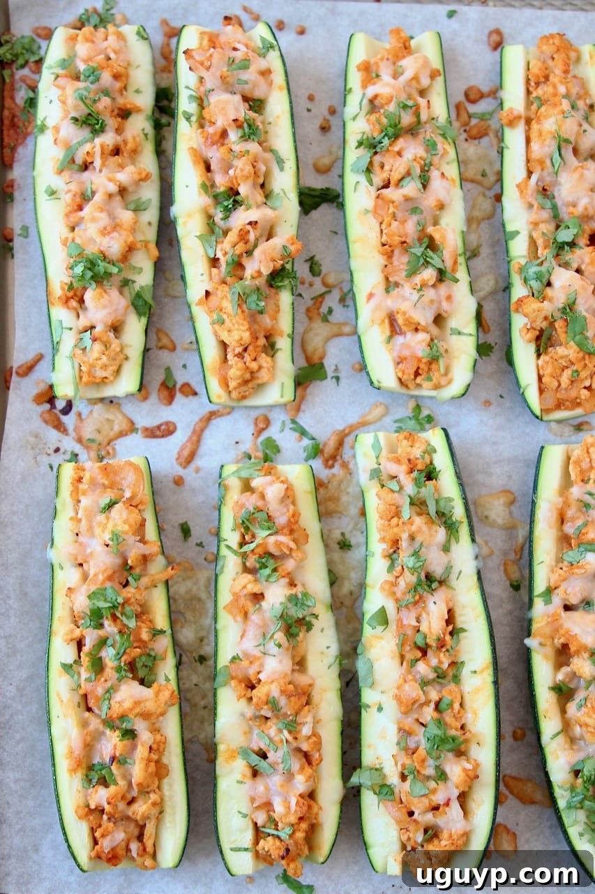 Buffalo Chicken Zucchini Boats on Parchment Lined Baking Sheet