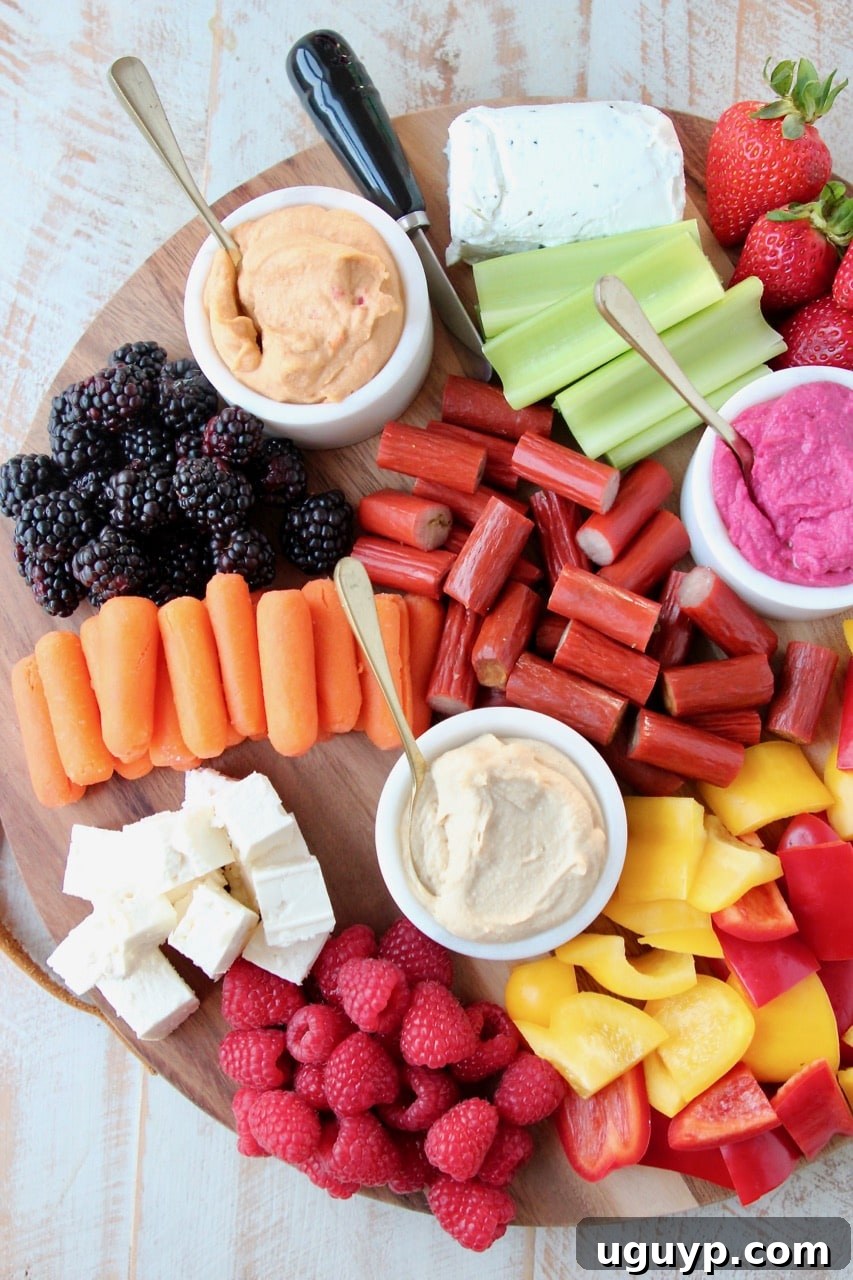 Low Calorie Charcuterie Board with Carrots, Celery, Bell Peppers, Hummus, Berries and Chicken Snack Sticks