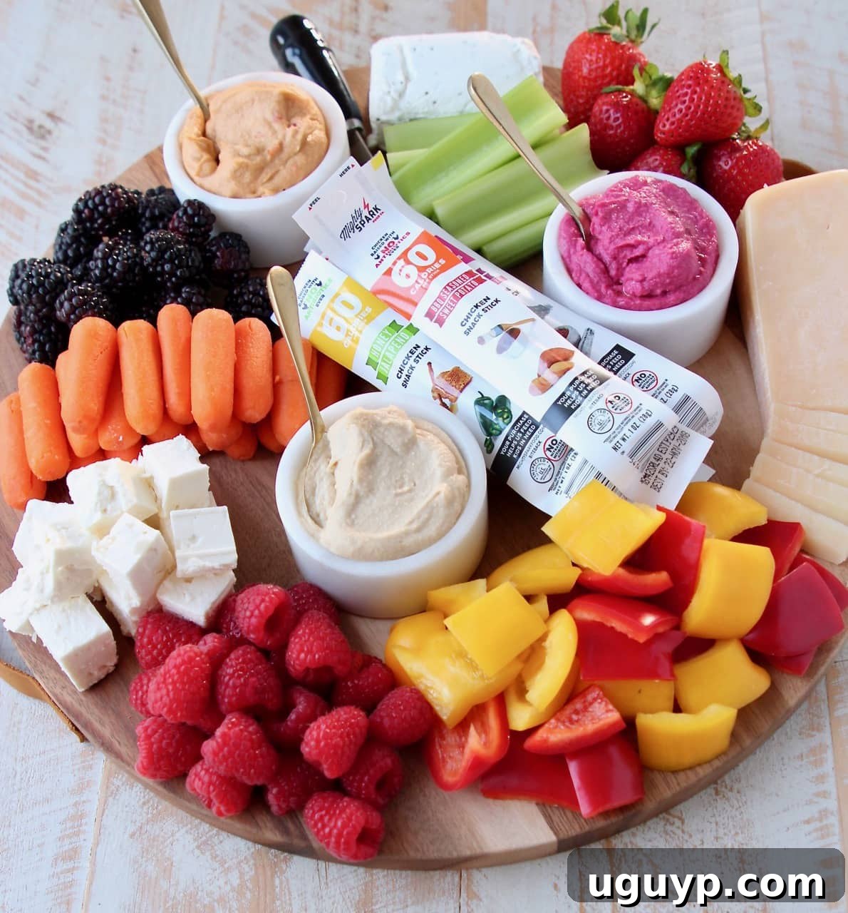 Low Calorie Charcuterie Board with Cheeses, Veggies, Berries, Hummus and Chicken Snack Sticks