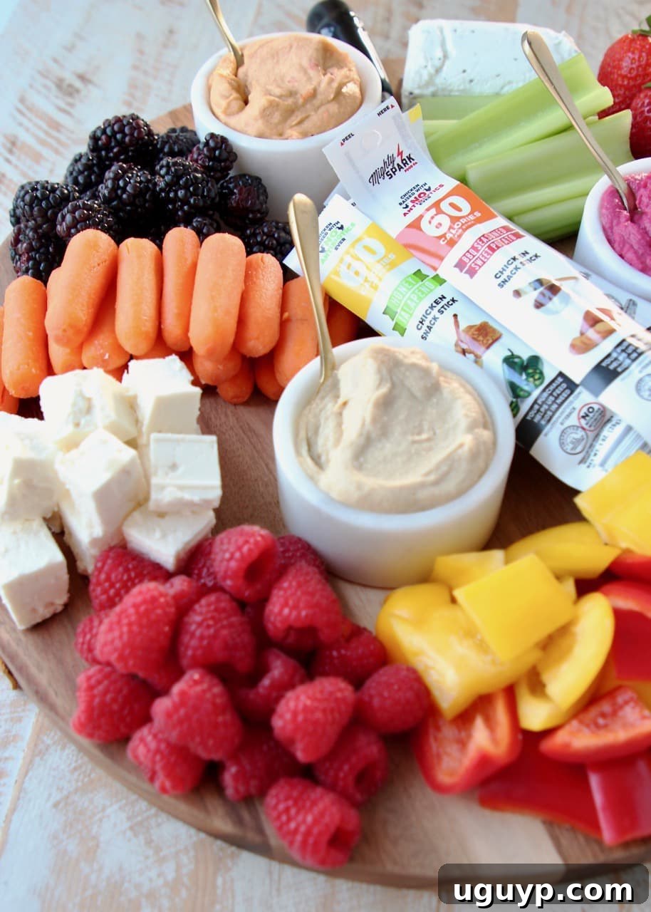 Low Calorie Charcuterie Board with Hummus, Veggies, Berries, Feta Cheese, Goat Cheese and Chicken Snack Sticks