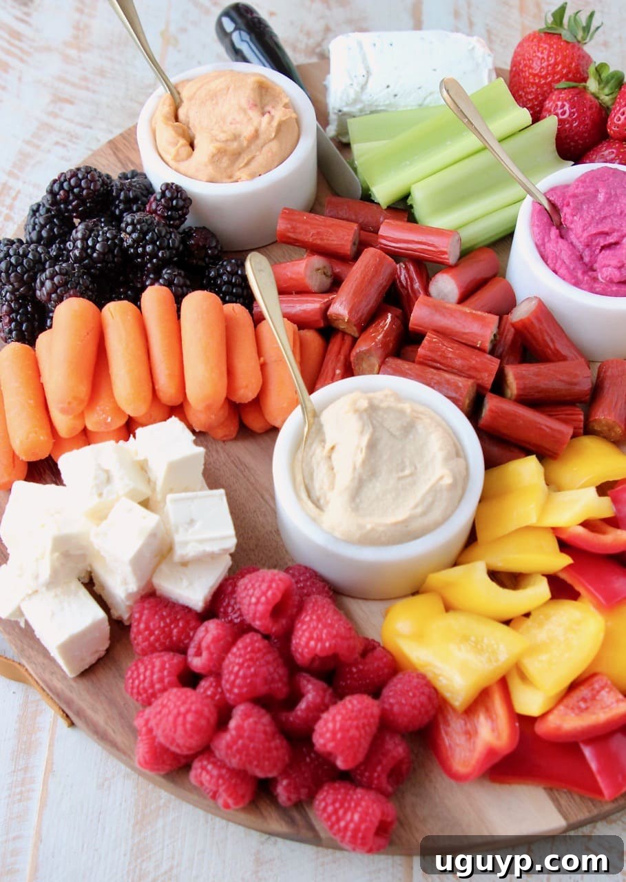 Low Calorie Charcuterie Board with Hummus, Veggies, Fruits, Cheeses and Chicken Snack Sticks