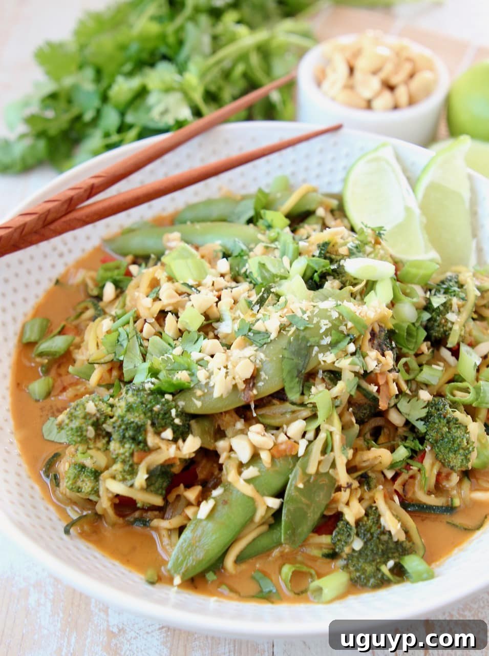 Vegan Pad Thai with Zucchini Noodles, Broccoli, Sugar Snap Peas, Carrots, Pad Thai Peanut Sauce, Scallions and Limes in a bowl