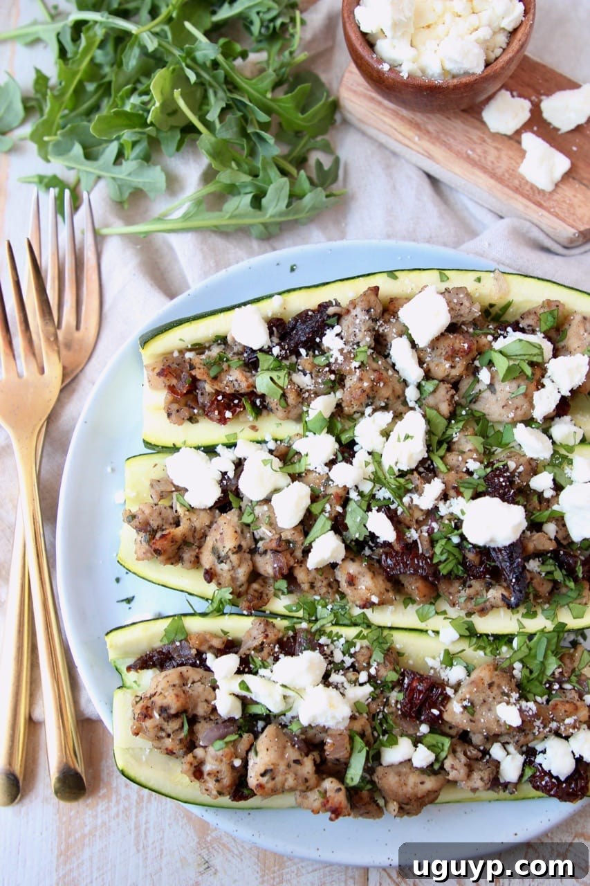 Overhead shot of cooked ground turkey stuffed in zucchini halves topped with crumbled feta cheese, ready to be served for a nutritious meal.