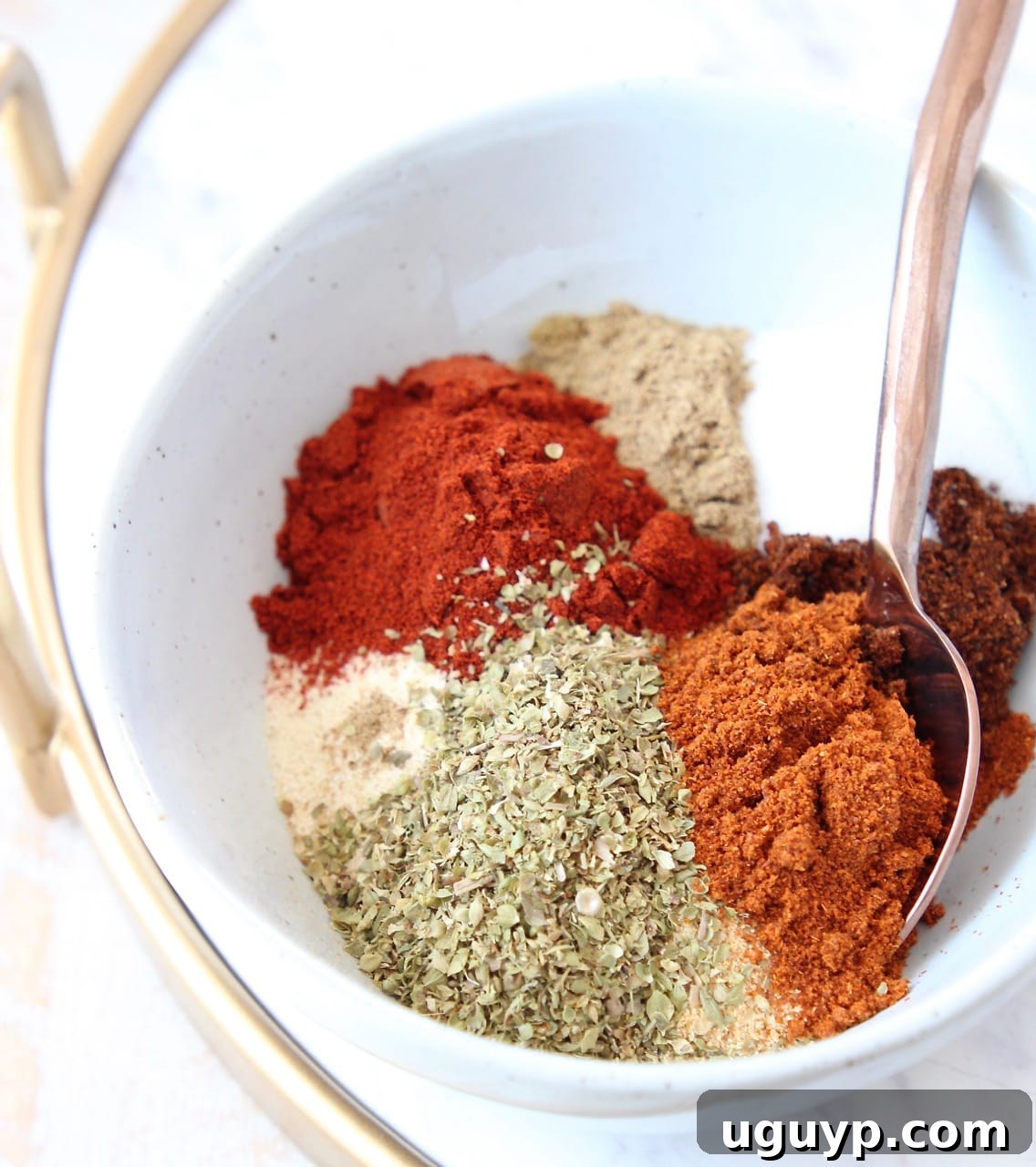 Assortment of dried herbs and spices, separated in bowls, ready to be mixed for homemade taco seasoning.