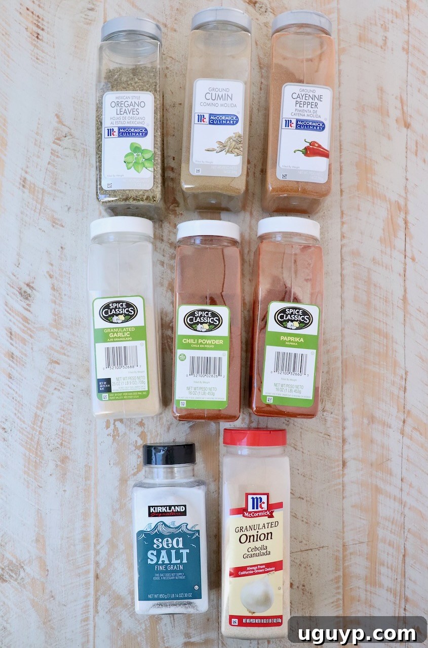All the individual taco seasoning ingredients laid out on a white wooden board, ready for mixing.