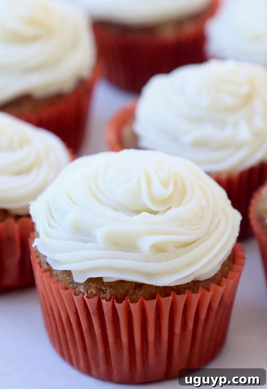 Delicious pumpkin cupcakes topped with swirling cream cheese frosting, ready to be enjoyed