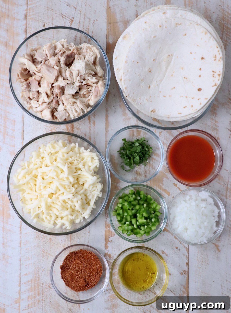 ingredients for buffalo chicken taquitos on a white wood board