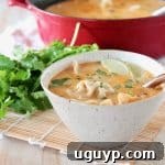 Thai coconut soup in bowl with potstickers, lime wedge and fresh cilantro