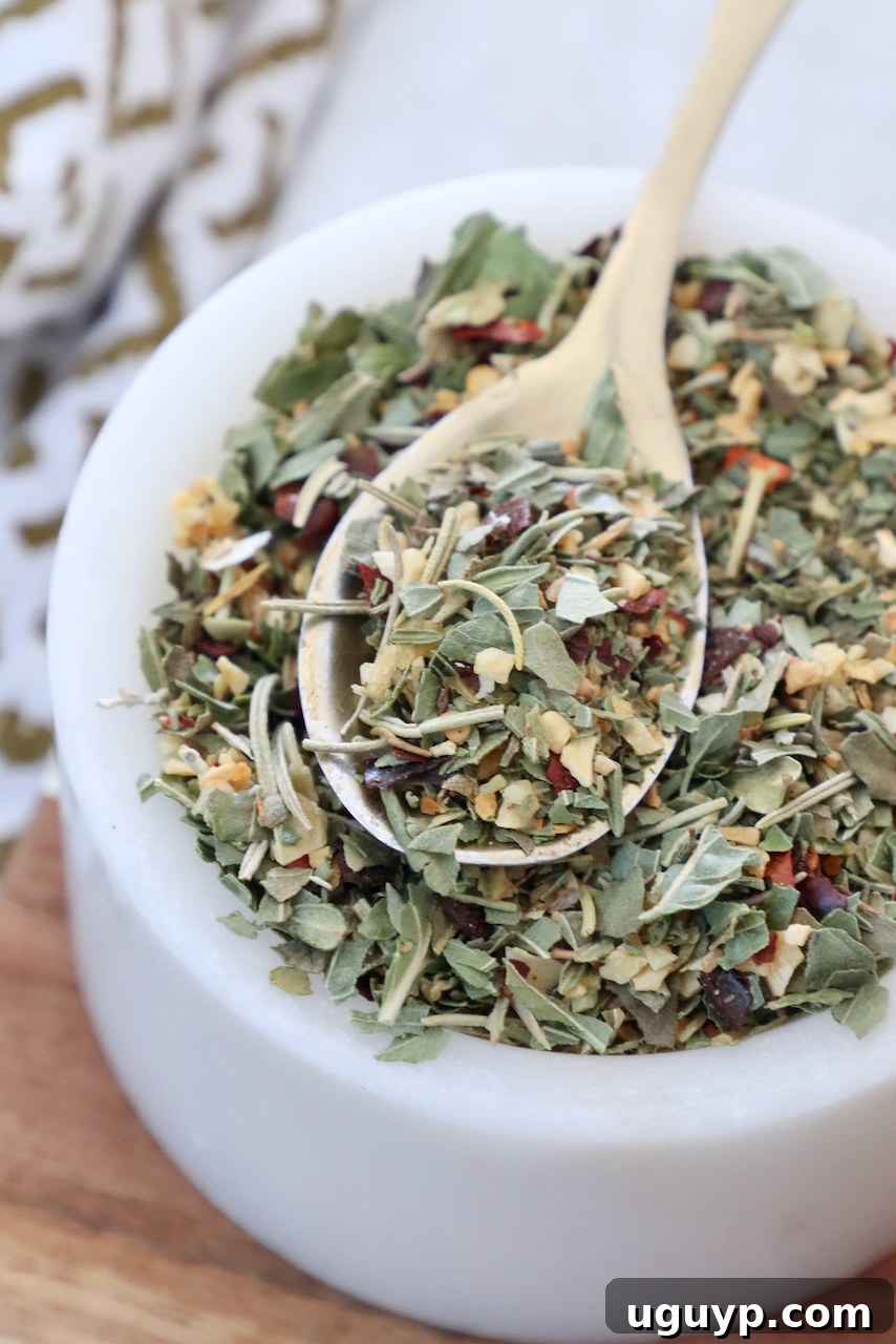 dried herbs and spices mixed together in a bowl with a spoon