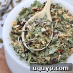 dried herbs and spices mixed together in a small white bowl with a spoon