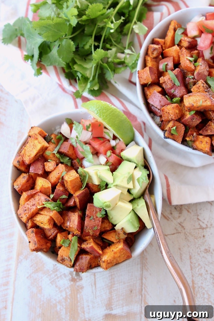 Overhead perspective of a vibrant vegan quinoa bowl, generously filled with fluffy quinoa, golden roasted sweet potatoes, fresh diced avocado, and bright pico de gallo, garnished with a lime wedge and cilantro. A copper fork is ready for enjoyment.