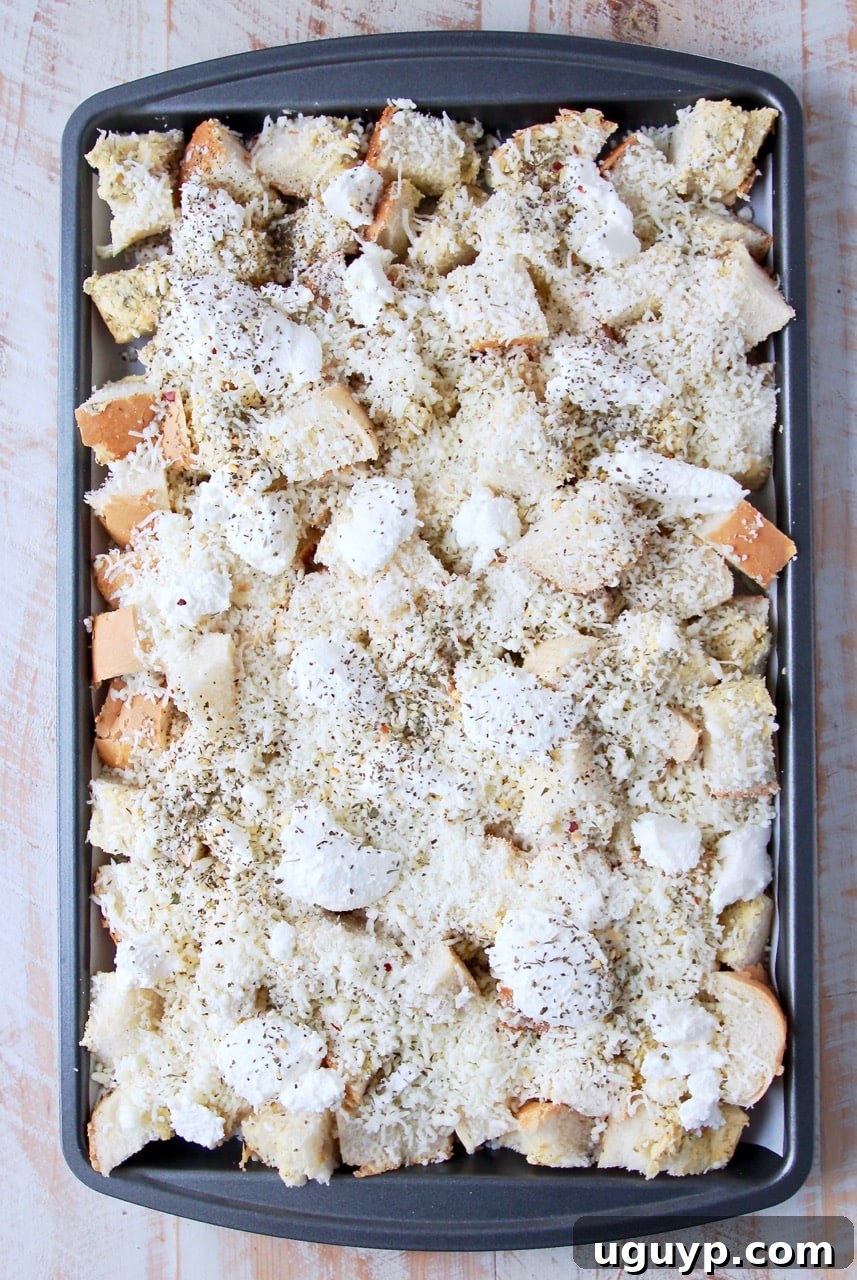 Garlic bread covered in cheese on a baking sheet