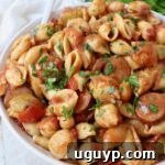 cooked pasta, sausage and peppers in spicy cajun tomato sauce in bowl