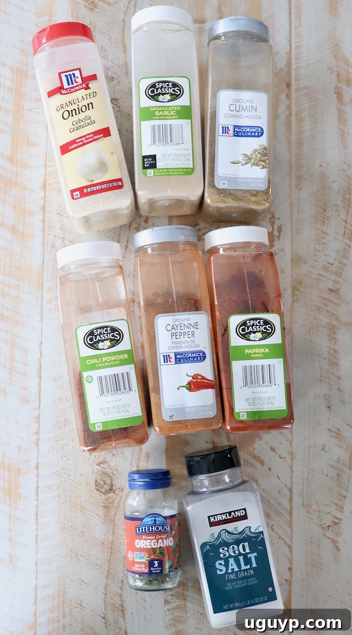 spices for fajita seasoning in plastic containers on white wood board