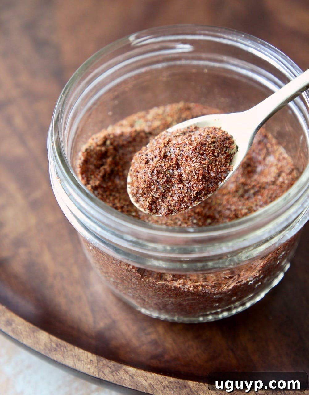 Fajita seasoning blend in a mason jar with a gold spoon full of the seasoning