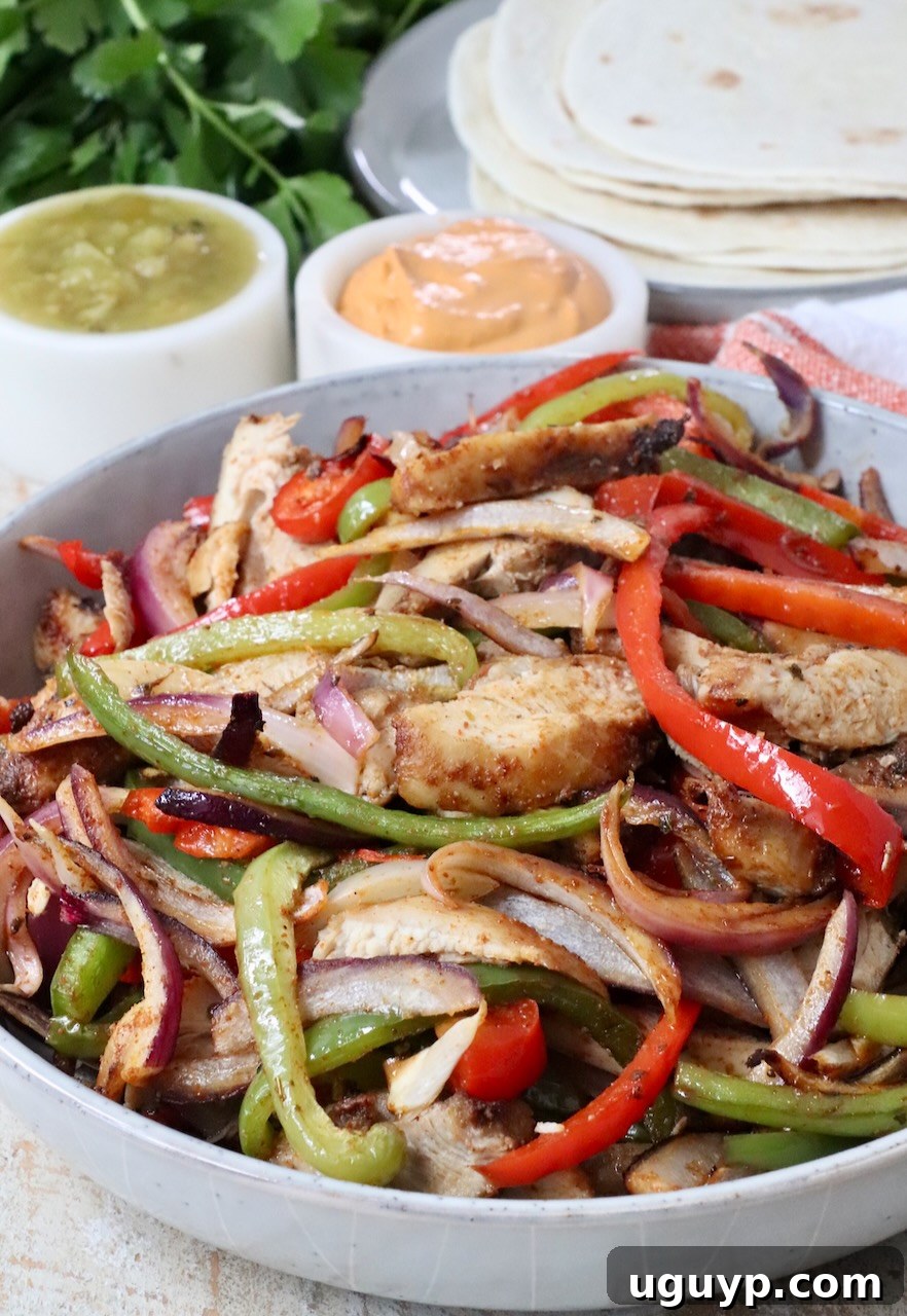 cooked chicken fajitas with bell peppers and onions in a bowl