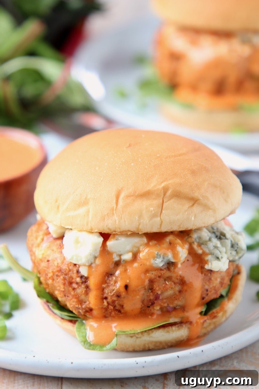 Buffalo chicken burger on a bun with blue cheese crumbles