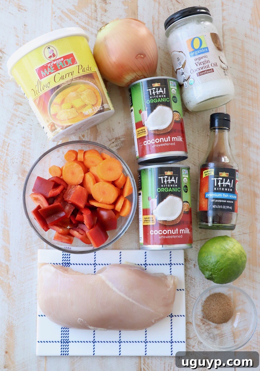 Fresh ingredients for Thai Yellow Curry, including coconut milk, curry paste, bell peppers, carrots, and chicken.
