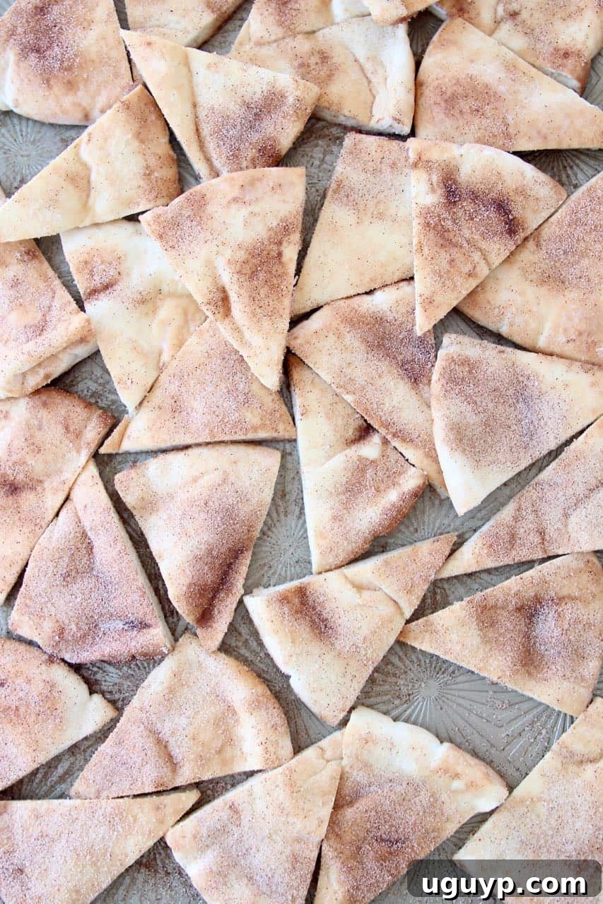 Freshly baked homemade cinnamon sugar pita chips cooling on a baking sheet