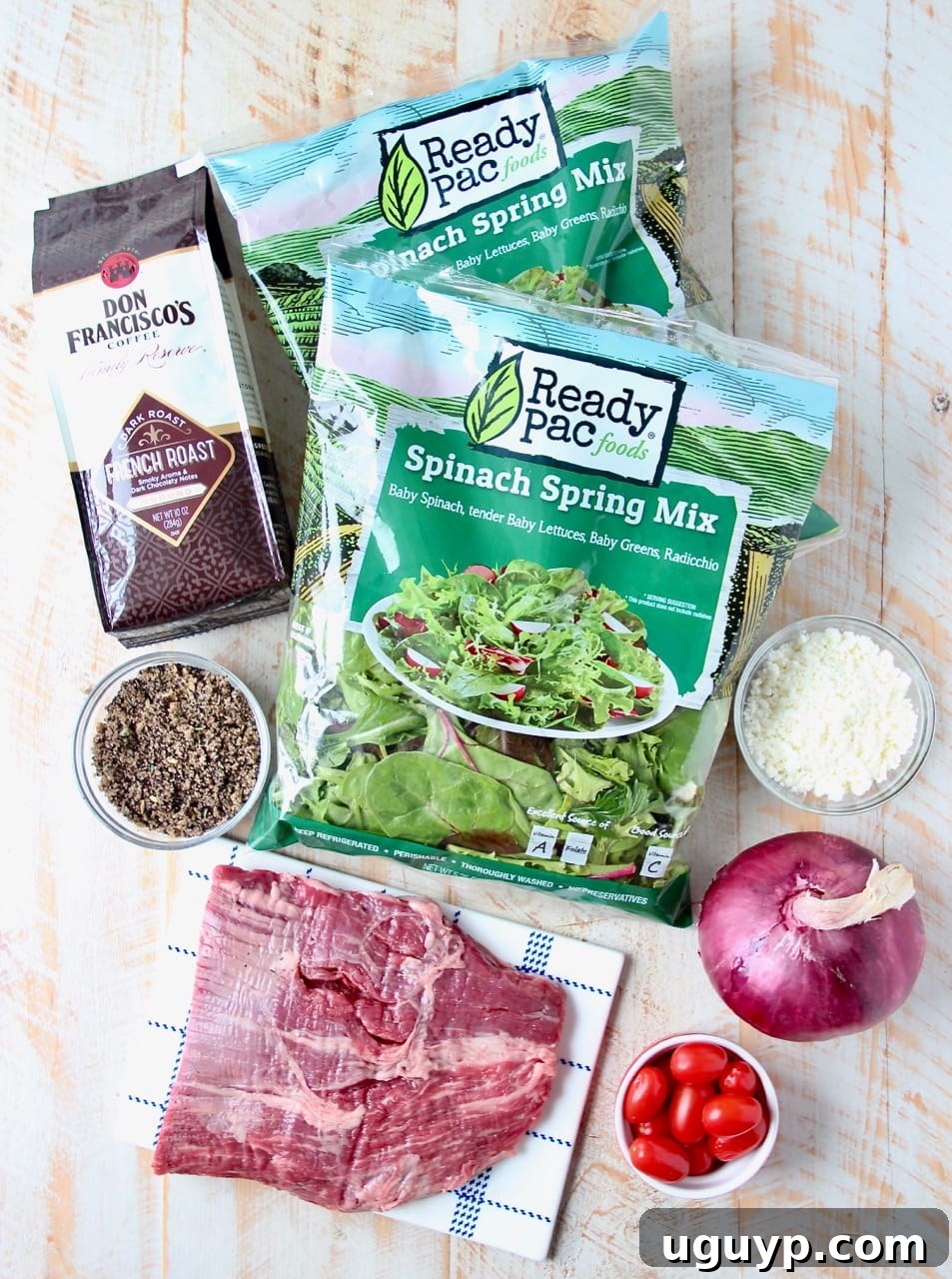 All the fresh ingredients laid out for making a coffee-crusted flank steak salad, including greens, vegetables, cheese, and the coffee rub blend.