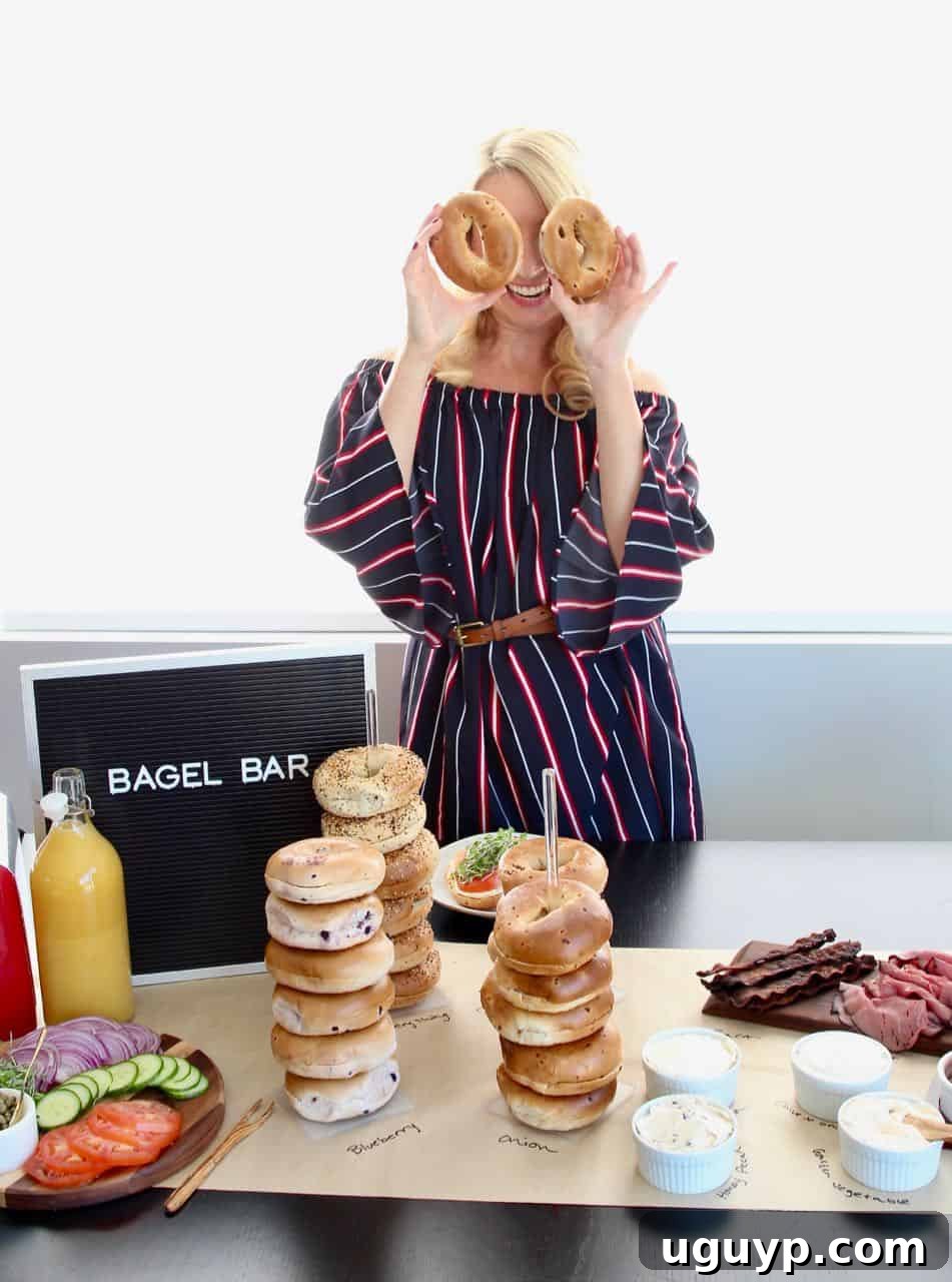 A beautifully set up bagel bar with a variety of bagels, cream cheeses, and fresh toppings.
