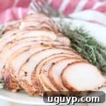 Sliced smoked turkey breast on plate with fresh rosemary and thyme
