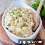 Creamed corn in white oval serving dish with wooden spoon
