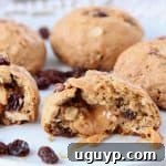 Oatmeal raisin cookie cut in half with caramel coming out of the center
