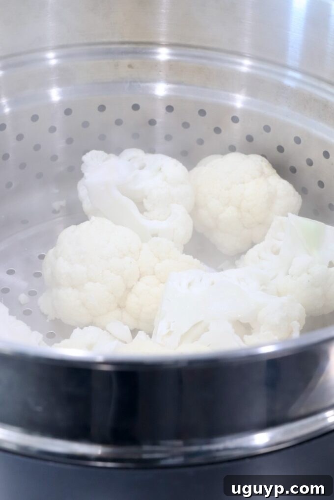 cauliflower in a steamer basket in a pot