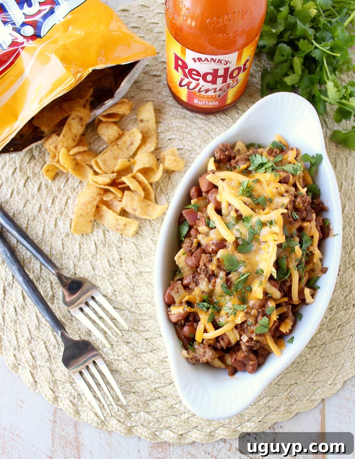 A delicious twist on a classic recipe: Frito Chili Pie given a spicy kick with buffalo sauce, green chilies, and spices, easily made in just 20 minutes!