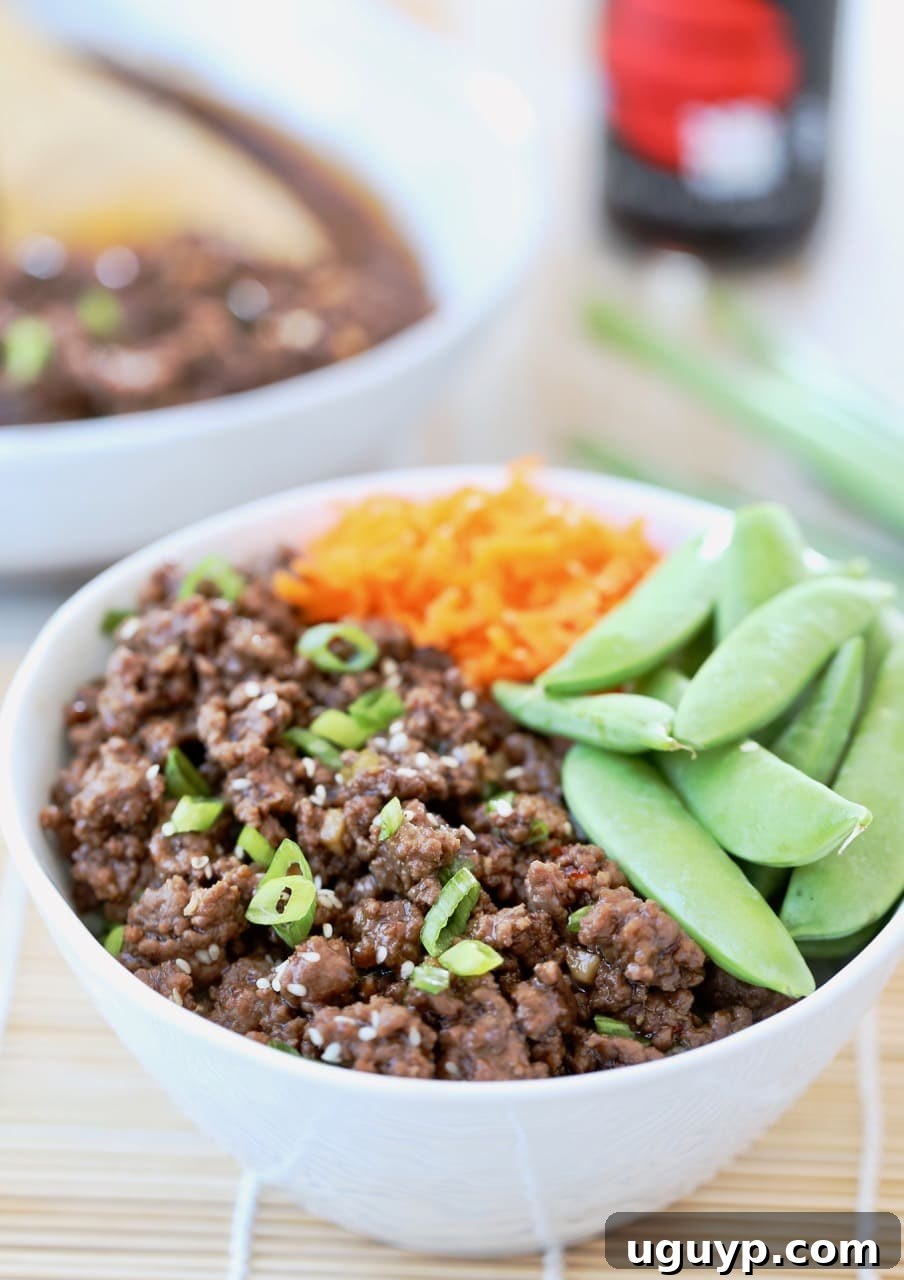 A vibrant Korean BBQ Beef Bowl, generously topped with crisp sugar snap peas and thinly sliced carrots, showcasing a balanced and flavorful meal.